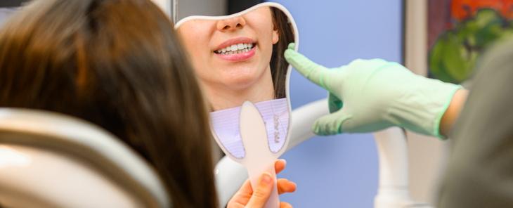 A Naturadent rendelőjében a fogorvos épp a fogfehérítés eredményét mutatja a páciensnek